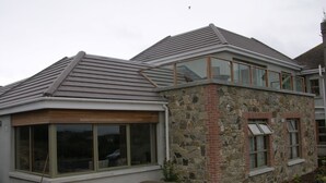 A modern house with a stone facade, large windows, and a covered patio area. - Samuel's Heritage Bed & Breakfast (Waterford)
