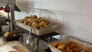 A breakfast buffet with bread, croissants, and muffins. - Hotel Waldblick (Donaueschingen)
