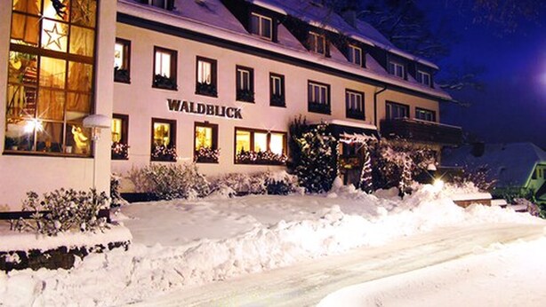 A hotel named WALDBLICK with a snow-covered exterior and illuminated windows. - Hotel Waldblick (Donaueschingen)