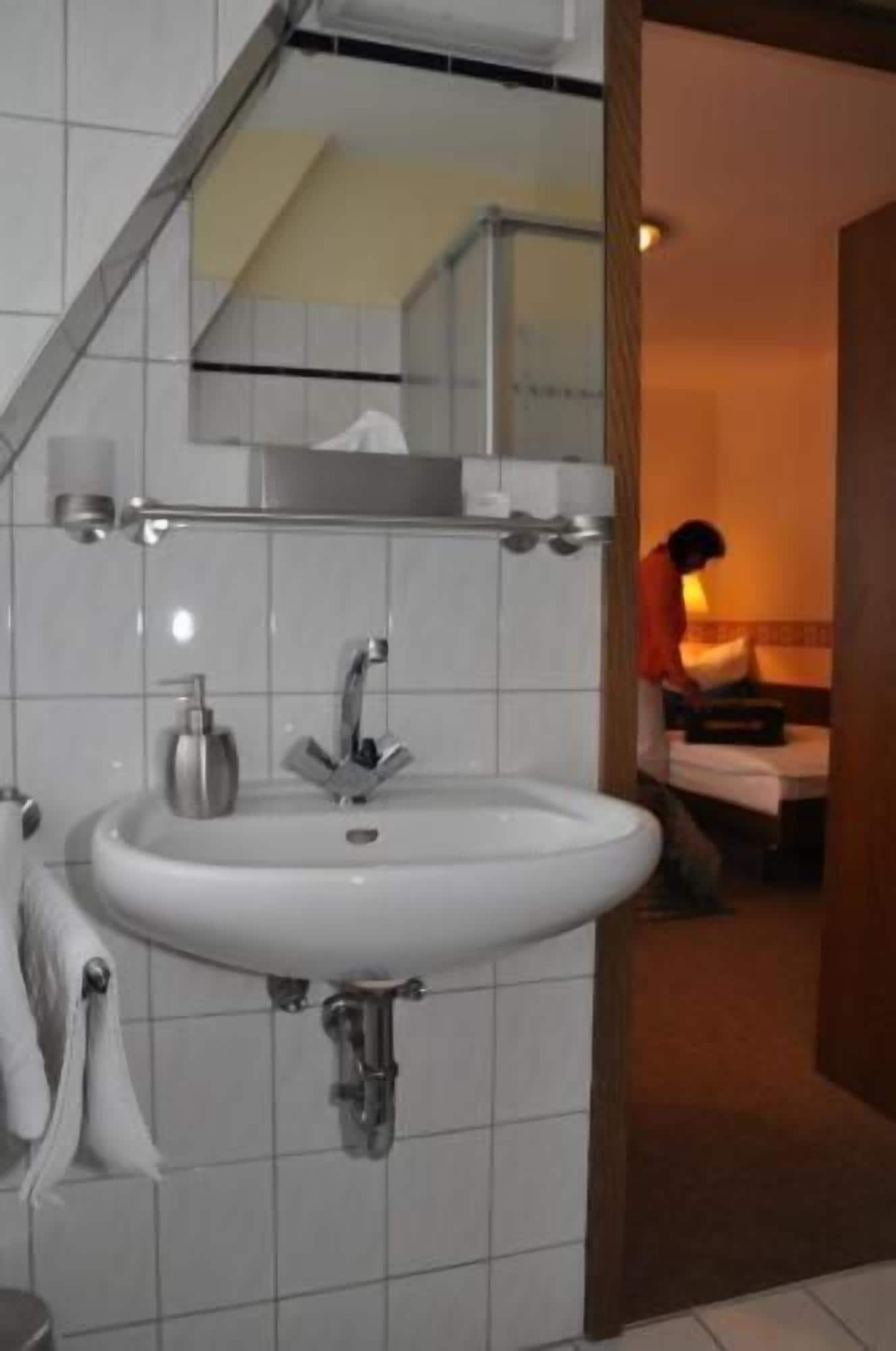 A bathroom with a white sink, a mirror, and a towel rack.