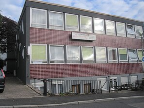 A two-story building with a sign indicating it is a hotel. - Hotel-12-Apostel (Pforzheim)