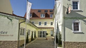 A building with a stone facade, a tiled roof, and a sign indicating it is a restaurant and café. - Hotel Restaurant Speeter (Weisenheim am Berg)
