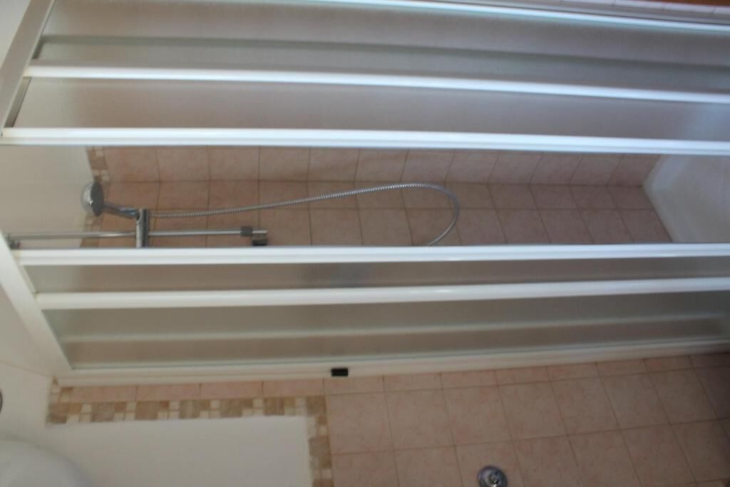 Ein Badezimmer mit Duschbereich, Toilette und Waschbecken.