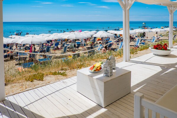 Aan een privéstrand, ligstoelen, parasols, een strandbar