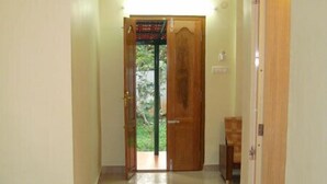 Un couloir avec une porte en bois, un banc et un tapis.