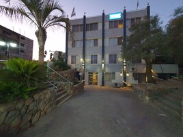 A multi-story hotel with a stone facade, multiple windows, and a flag.