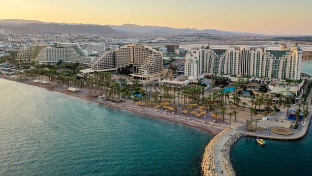 A coastal resort with multiple high-rise buildings, a beach promenade, and a marina.