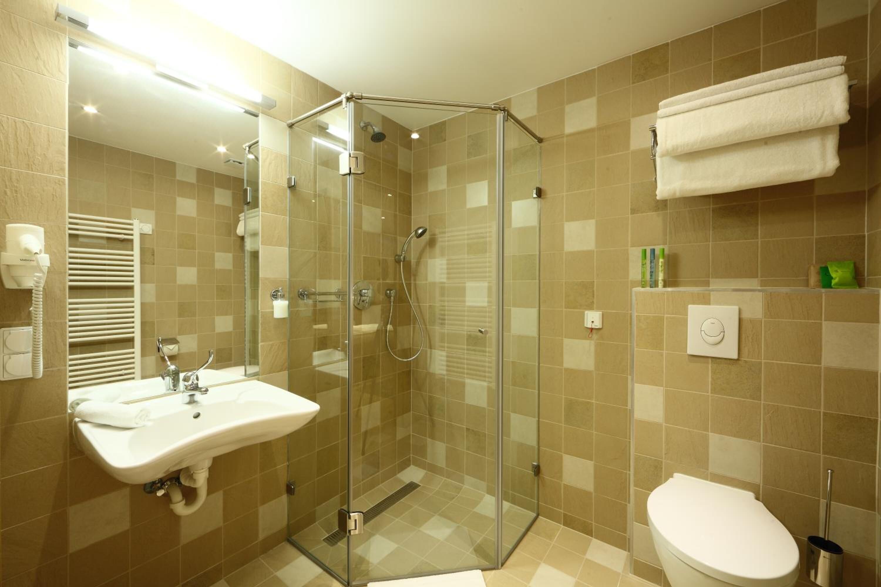 Une salle de bain avec une douche à parois de verre, un lavabo et des toilettes.