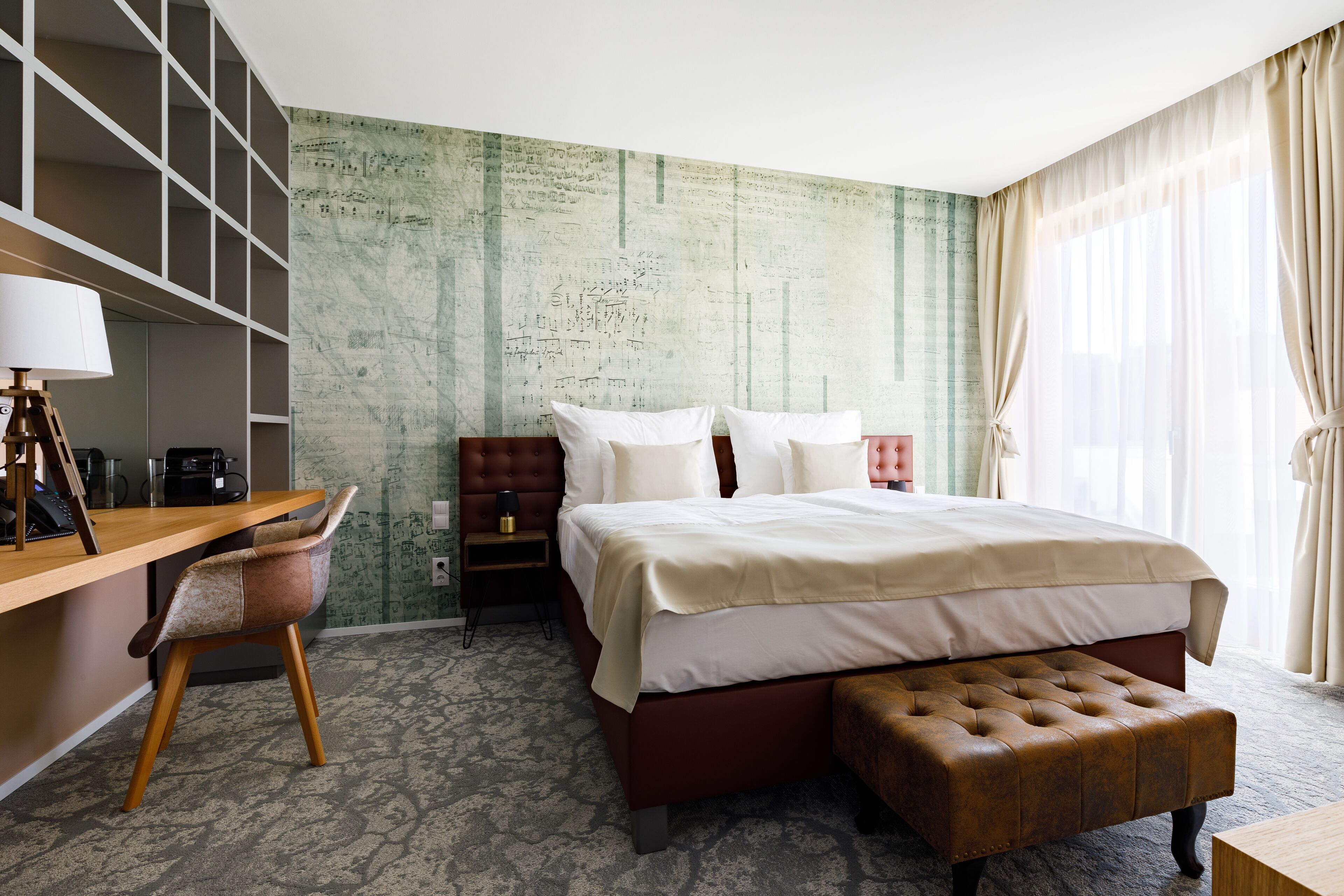 Habitación de hotel con una cama grande, un escritorio, una silla, una mesita y una pared con textura.