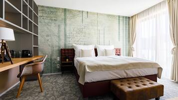 Habitación de hotel con una cama grande, un escritorio, una silla, una mesita y una pared con textura.