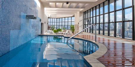 Una piscina al aire libre, sillones reclinables de piscina