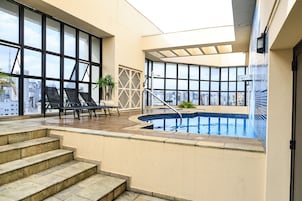 Una piscina al aire libre, sillones reclinables de piscina