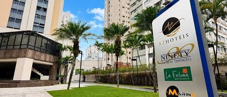 Letrero de hotel que anuncia servicios como restaurante, gimnasio y número de contacto.