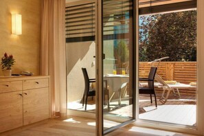 Ein modernes Zimmer mit einer Schiebetür zu einem Außenbereich mit Terrasse.