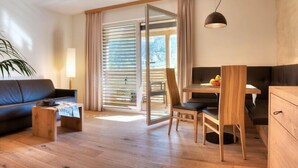 Una sala de estar moderna con sofá, mesa de centro y un comedor con mesa y sillas.