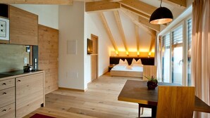 Un dormitorio moderno con techo de madera, una cama con ropa de cama blanca, una mesita de noche y una ventana con cortinas.
