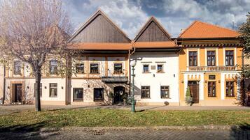 A hotel with a traditional architectural style, featuring a central entrance, multiple windows, and a sign indicating it is a hotel.