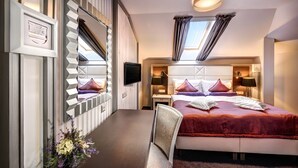 Una habitación de hotel moderna con una cama grande, un escritorio y un televisor.