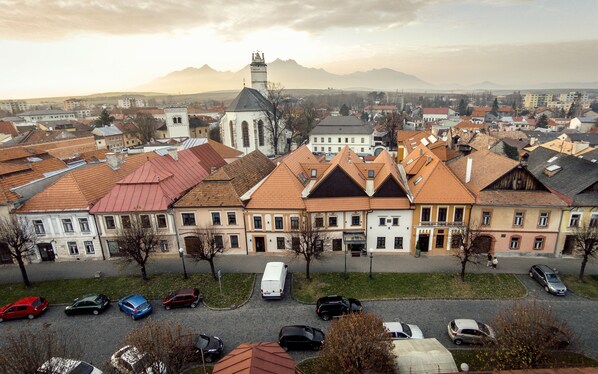 A historic building with a prominent tower and a church nearby. - Boutique Hotel Hviezdoslav (Kezmarok)