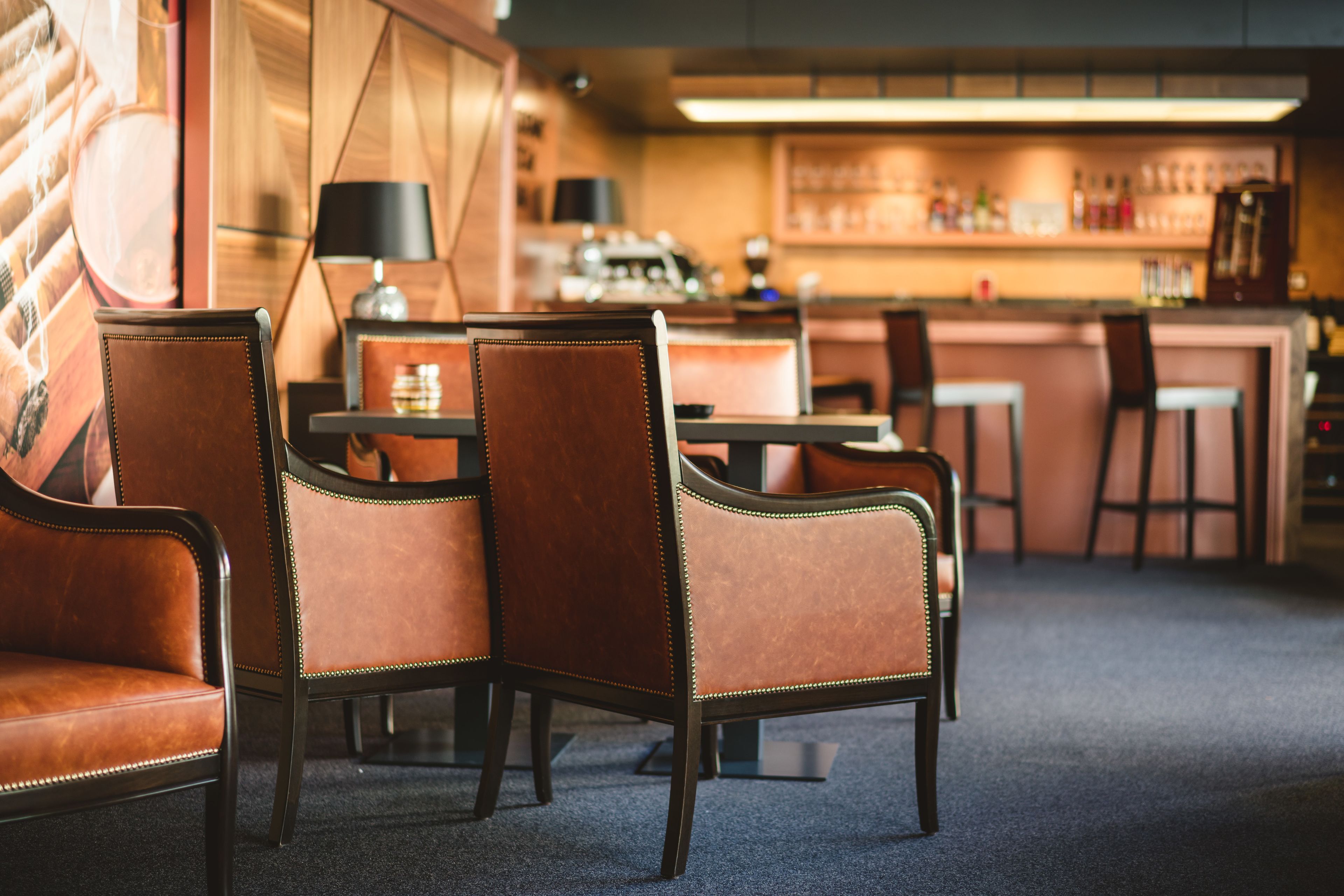 A bar area with leather chairs and a bar counter.