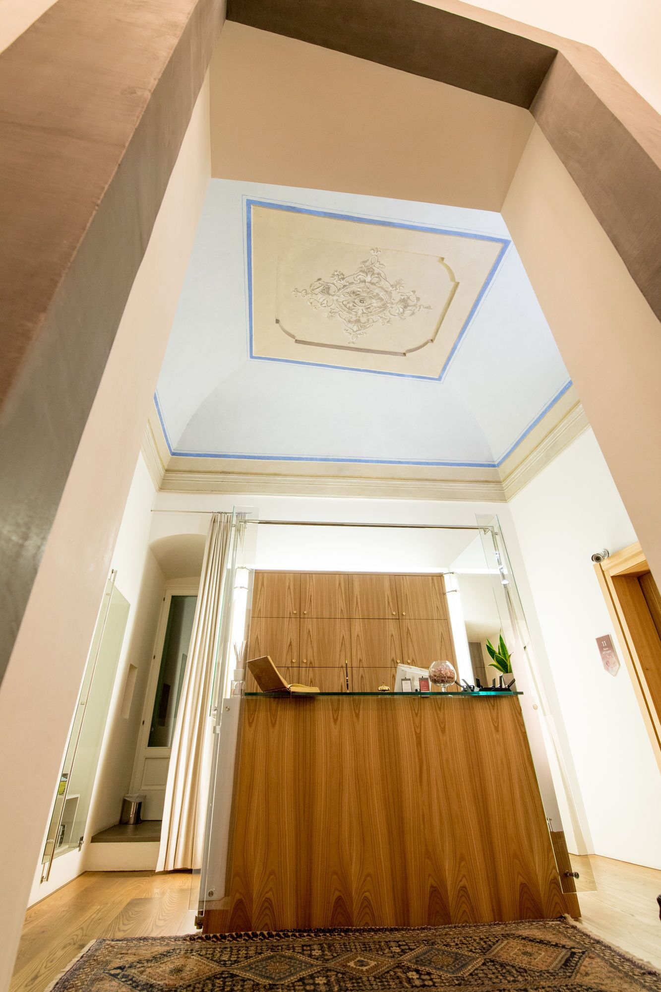 Un'ampia stanza con una reception in legno, un tappeto a motivi e un soffitto decorato.