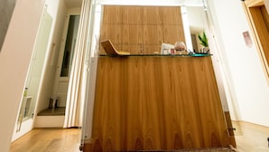 Une pièce spacieuse avec un comptoir d’accueil en bois, un tapis à motifs et un plafond orné d’un décor.