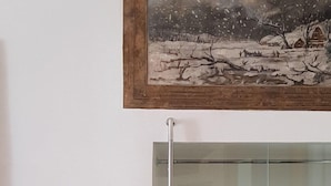 Une pièce avec une vitrine et un tableau encadré accroché au-dessus.