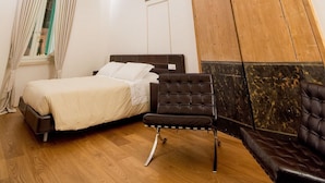 Une pièce comprenant un lit, une armoire en bois et un plafond orné de peintures.