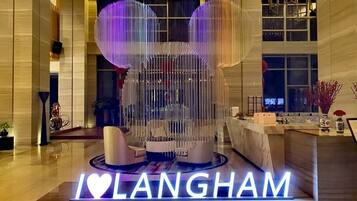 A reception area with a 'I ♥ LANGHAM' sign, a modern seating arrangement, and a large window in the background.