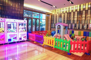 A children's play area with colorful fences, a slide, and claw machines.