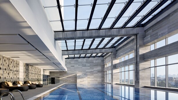 A modern indoor swimming pool with clear glass walls, a tiled floor, and a seating area with loungers. - Langham Place Xiamen (Xiamen)