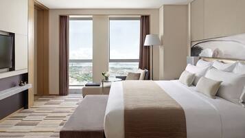 Una habitación de hotel moderna con una cama grande, televisión y vistas a la ciudad.