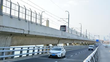 A highway with multiple lanes, a pedestrian walkway, and a bridge with a metal railing.