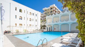 A swimming pool with sun loungers, a lifeguard stand, and a flag. - Hotel Falcone (Vieste)