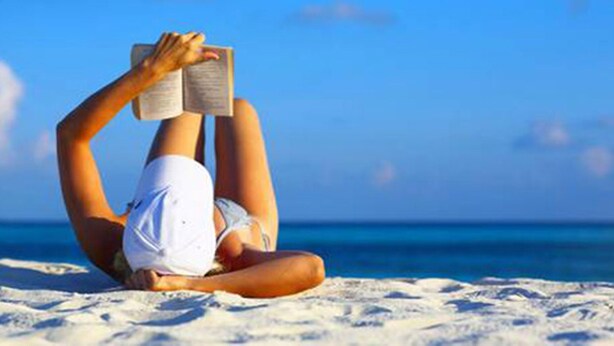 A person lying on a sandy beach, reading a book. - Centro Vacanze Cavallino Opera Nascimbeni (Cavallino-Treporti)