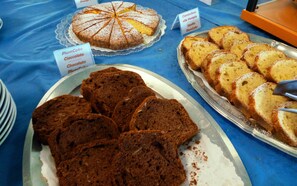 Une table garnie de divers gâteaux et pâtisseries, notamment un gâteau aux prunes et un gâteau au chocolat.