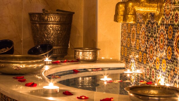A bathroom with a marble sink, a gold faucet, and a decorative tiled wall. - Ryad Amiran & Spa (Marrakech)