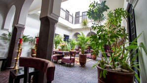 A spacious courtyard with multiple seating areas, potted plants, and a central fountain. - Ryad Amiran & Spa (Marrakech)