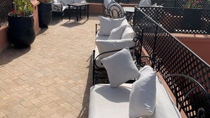 A rooftop terrace with outdoor seating, potted plants, and a view of the cityscape. - Riad Abaka by Ghali (Marrakech)