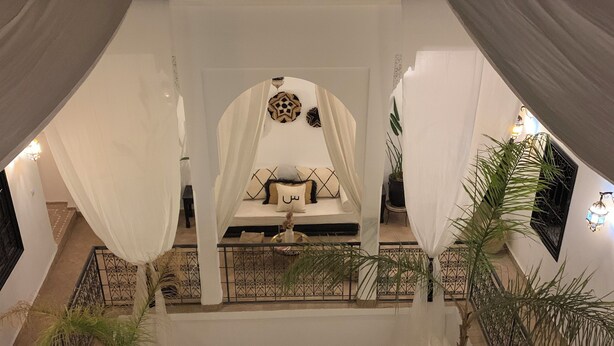 A multi-level atrium with a central seating area, a pool, and a staircase. - Riad Sin (Marrakech)