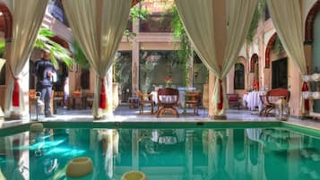 Una piscina techada, sillones reclinables de piscina