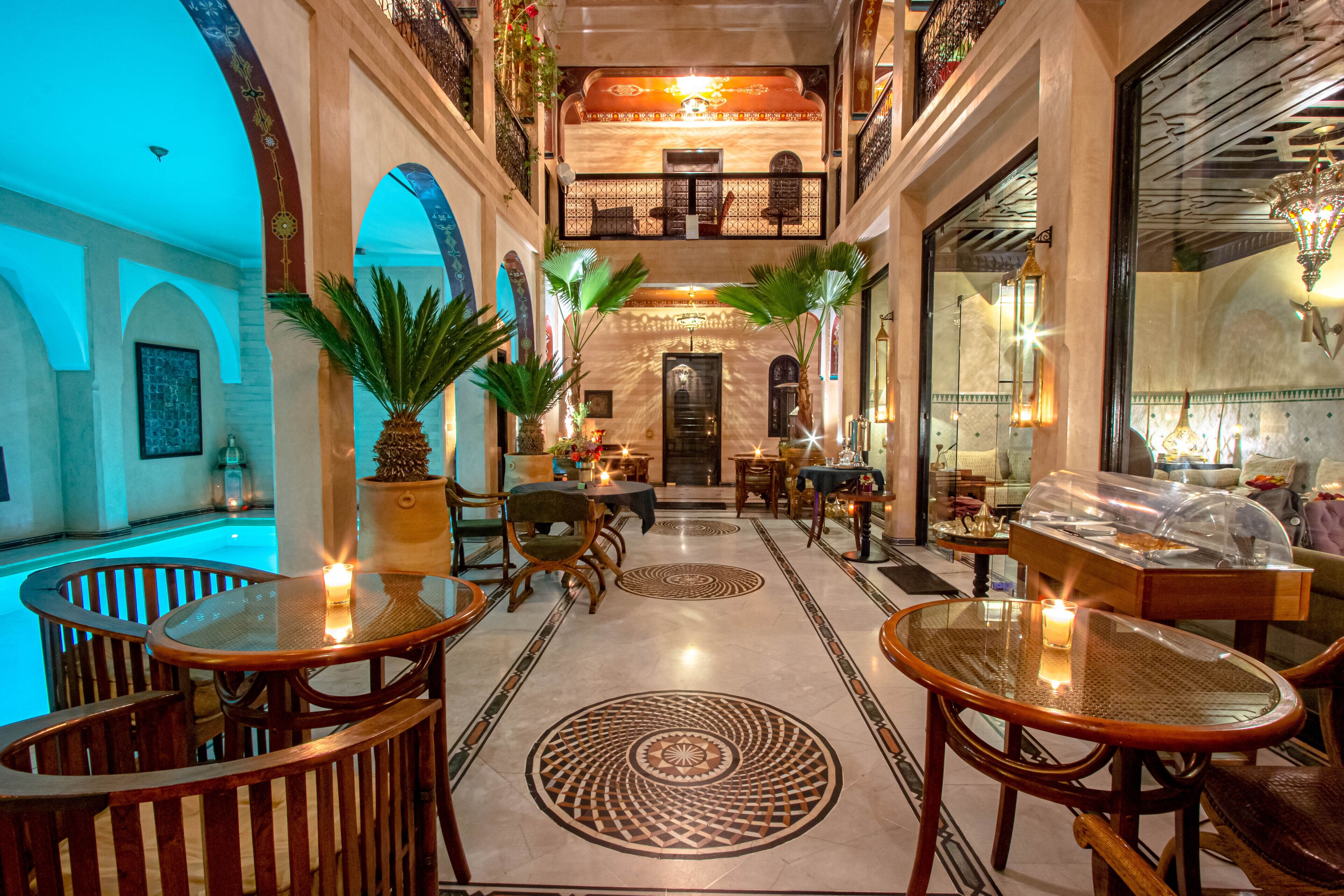 A luxurious lobby with a pool, ornate arches, and a grand staircase.