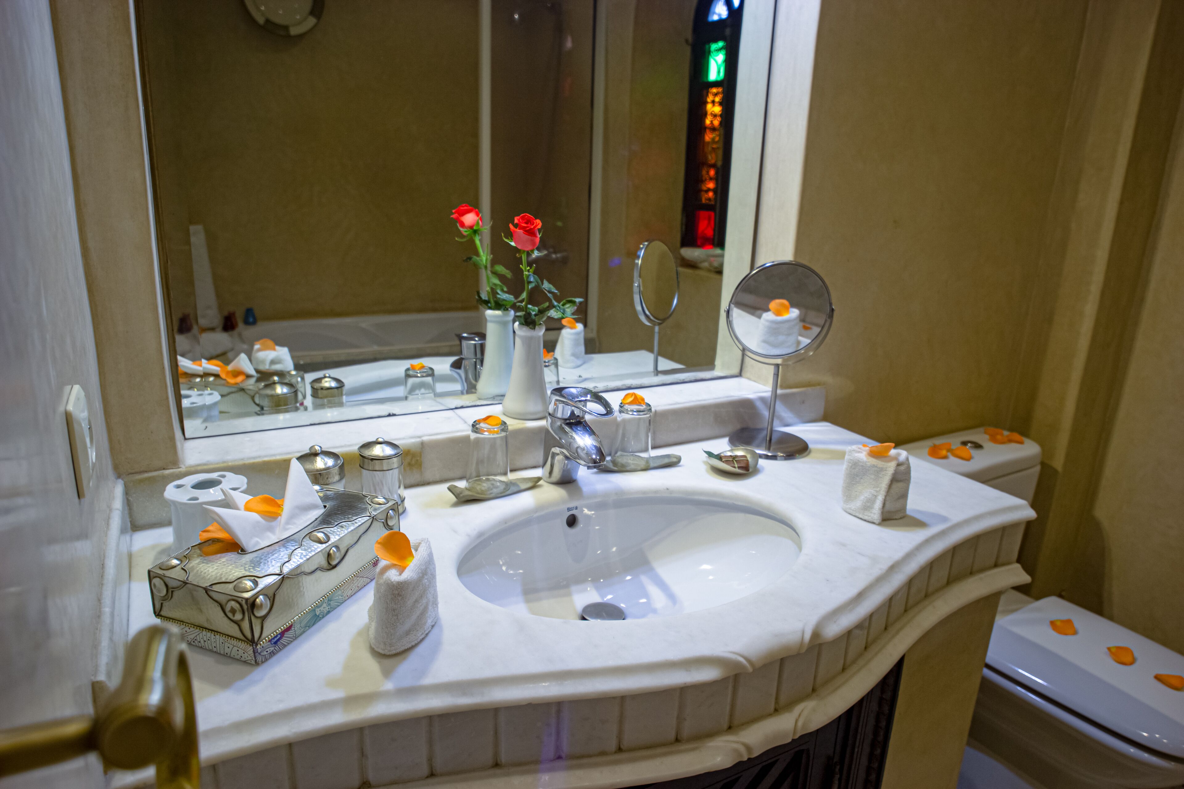 A bathroom with a sink, mirror, and toiletries.