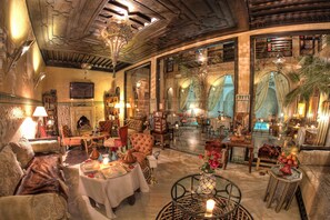 A luxurious interior with a cozy seating area, a dining table, and ornate decor.