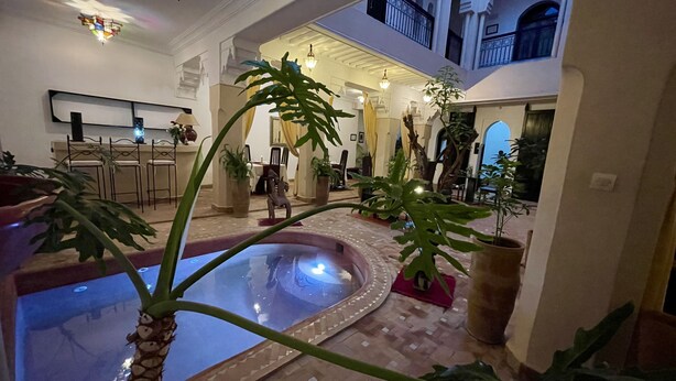 A spacious indoor area with a central water feature, multiple seating areas, and a variety of potted plants. - Riad Dar Foundouk & Spa (Marrakech)