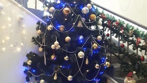 A decorated Christmas tree with ornaments and lights, a staircase with festive decorations, and a Santa Claus figure. - Hotel 12 (Kharkiv)