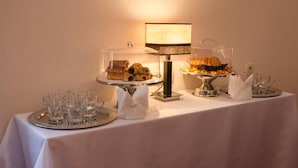 A table with a white tablecloth, clear glassware, and various pastries and desserts. - Hotel 12 (Kharkiv)