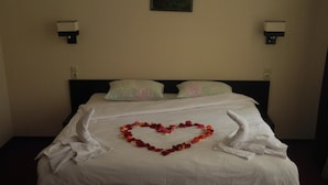 A neatly made bed with a heart-shaped flower arrangement and towels folded on either side. - Hotel 12 (Kharkiv)