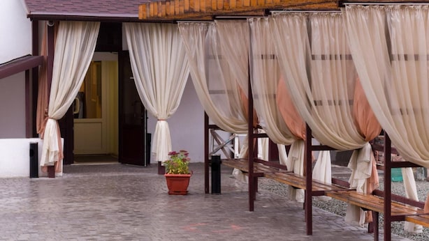 A covered outdoor seating area with benches and potted plants. - Hotel 12 (Kharkiv)