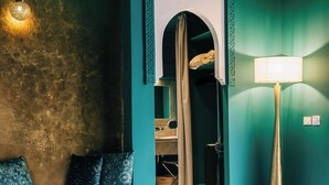 A room with a bed, a round coffee table, a lamp, and a patterned rug. - Riad Nashira & Spa (Marrakech)